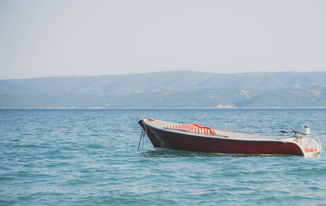 孤独的红色小船停泊在公海上