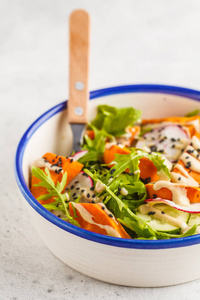 彩虹素食沙拉配芝麻菜, 红薯, 萝卜, 芝麻酱敷料和黄瓜, 白色背景。健康素食概念