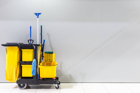 机场墙上的黄色拖把桶和清洁设备和男士洗手间的标志