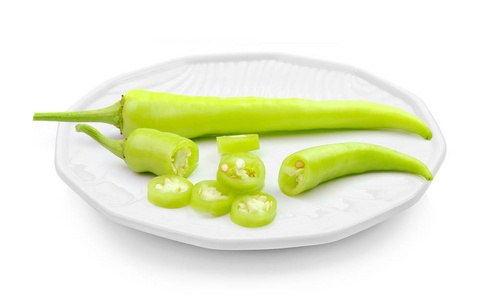 在白色背景下的盘子里的绿辣椒