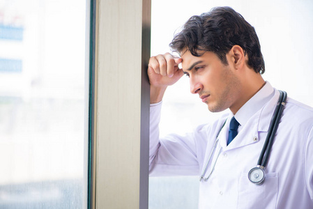 站在窗前的年轻英俊的医生
