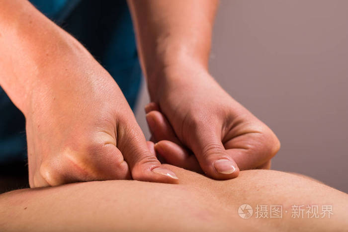 按摩师近距离观察男性背部深部组织体按摩治疗