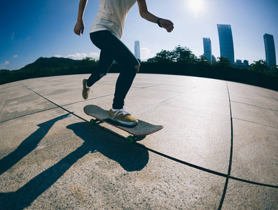 运动的年轻妇女 sakteboarding 在城市