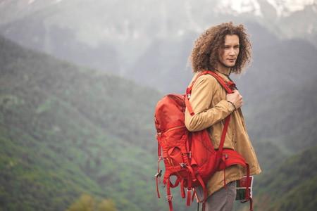 男子旅行者与红色背包放松户外与洛基山脉背景