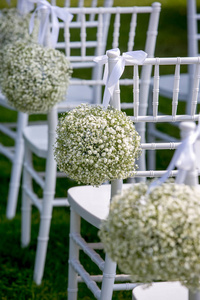 夏季户外婚礼装饰。白色椅子装饰与果蝇球, 垂直视图