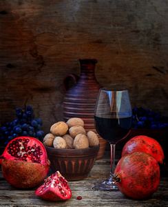 石榴 核桃 葡萄和葡萄酒的一个木制的背景