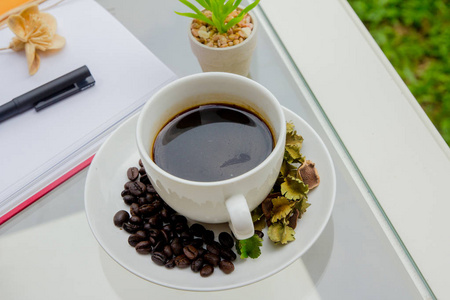 特写镜头黑咖啡在咖啡桌上与咖啡豆, 笔记本, 股票摄影师