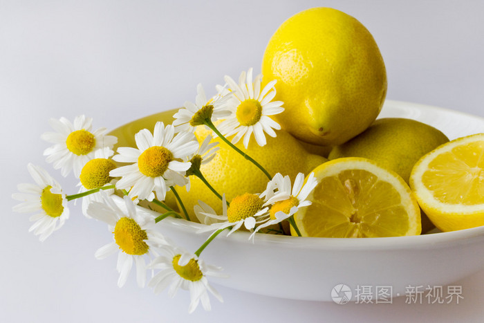 黄柠檬新鲜洋甘菊花在白板上