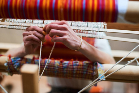 女性手在纺织品生产过程中手工织机, 特写