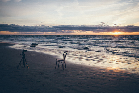 椅子在海与三脚架。复古粒状薄膜外观