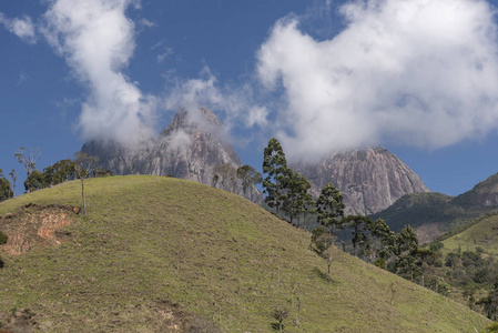 风景秀丽的岩石山景观与美丽的云, 绿色的树木和蓝天, 特雷斯皮科斯公园, 农村塞拉多马, 里约热内卢州, 巴西