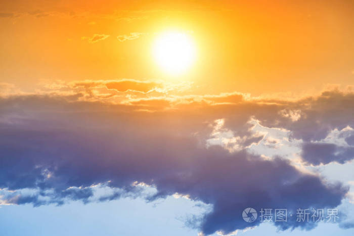 日落在橙色的天空与大太阳和蓝色云彩