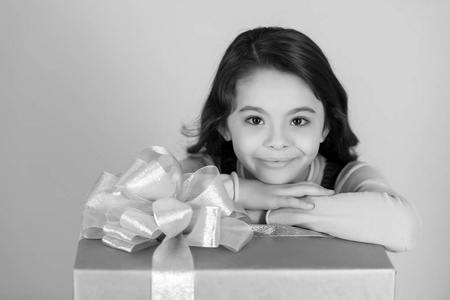 女孩微笑与礼物箱子, 丝带弓在蓝色背景