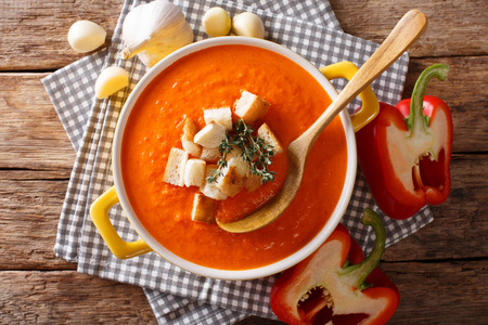 自制的素食甜椒汤与面包和草药特写在桌子上。水平顶部视图从 abov