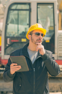 在建筑工地上戴着平板电脑的安全帽的男领班
