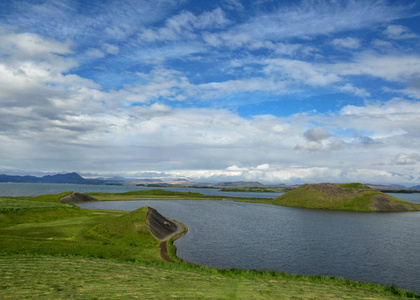 在美丽的阳光明媚的日子里, 在蓝天和云朵中, 可以欣赏到 myvatn 湖的美景, 看到绿色的伪国家和岛屿。冰岛北部的热门旅游目