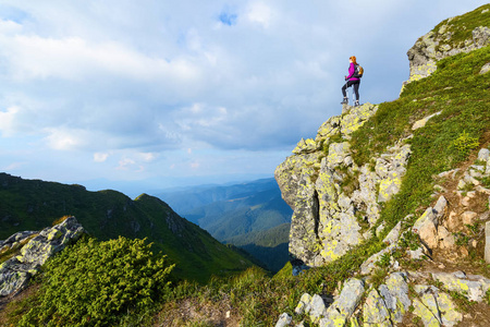 运动型的背袋是站在悬崖边，观看上无尽广阔的山脉景观在阳光灿烂的日子