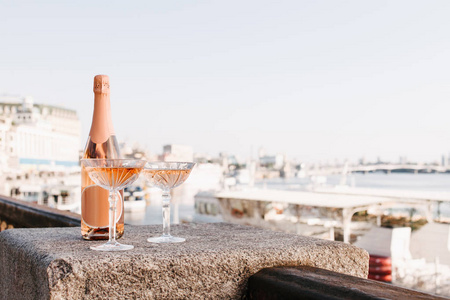江边路堤上两杯香槟的特写图