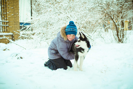 赫斯基狗在雪上的小男孩