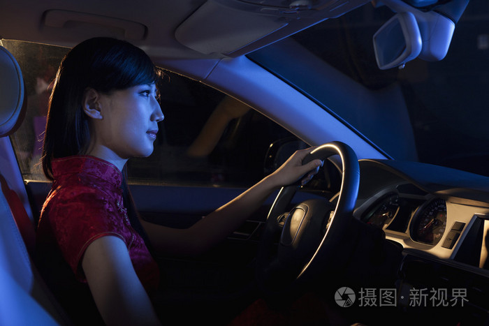在传统的中国服饰,在夜间开车的女人照片-正版商用08k