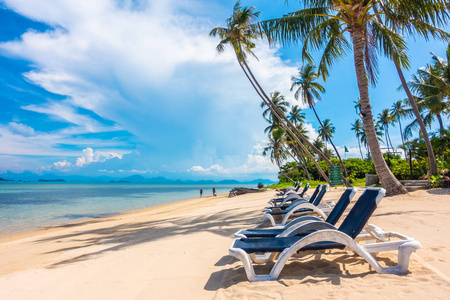 美丽的户外景观与雨伞和椅子上的海滩和海洋与椰子棕榈树度假和旅游