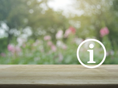 在木桌上的信息标志图标在花园, 商业和工业客户支持概念的模糊粉红色花卉和树木