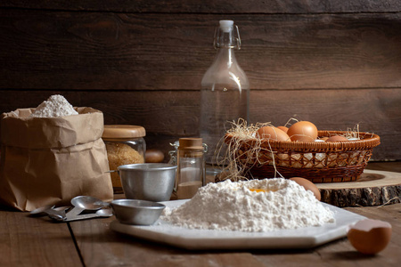鸡蛋, 面团和面粉在木桌上, 在面包店里有一个对象的背景