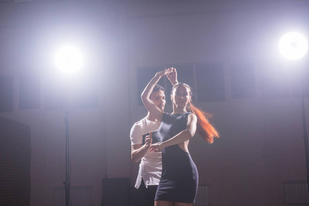 在音乐会的灯光和烟雾下, 熟练的舞者在暗室里表演。感性情侣表演艺术和情感的当代舞蹈