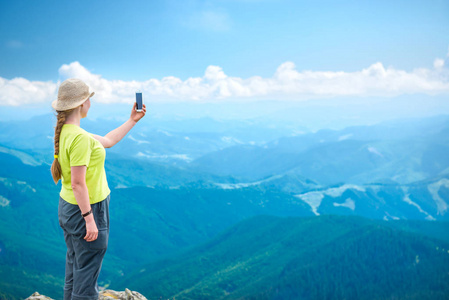 站在山崖上的年轻女子, 乘坐智能手机自拍旅行