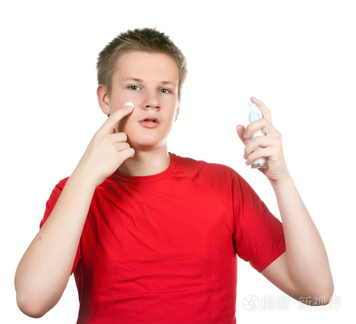 这个男孩在青少年问题的年轻皮肤针对点的奶油
