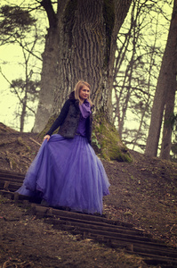 森林与紫罗兰色礼服的女人