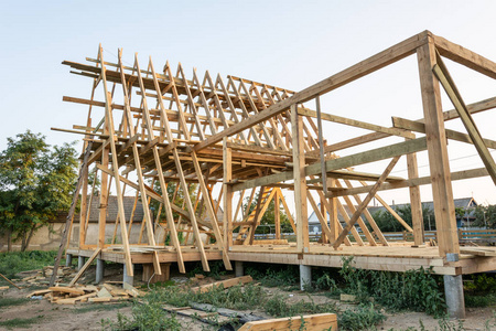 在夕阳下建造一个新家的木椽。新房子建筑内部与暴露的框架