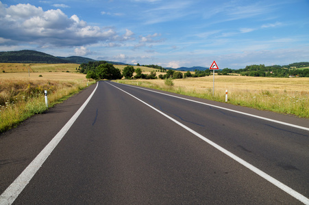 与空道路及交通标志右弯前方的田园风光