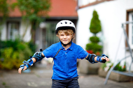 小男孩的画像在安全防护衣服 scating 与滚筒。活跃运动的孩子在夏天做运动