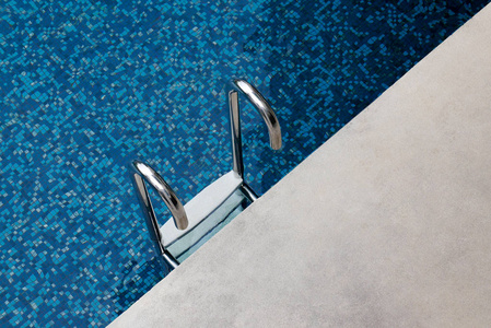 楼梯下到游泳池蓝色瓷砖游泳池