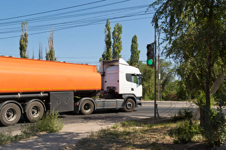 一辆卡车与一辆坦克运输石油产品在工业地区在尘土飞扬的道路上行驶