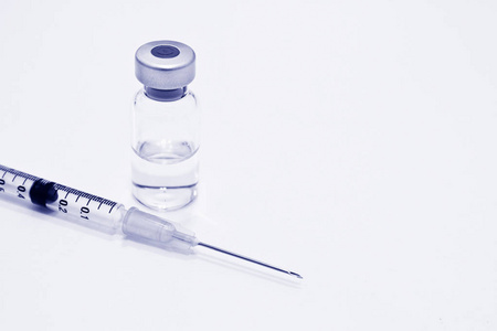 药瓶的药物或疫苗和1毫升塑料注射器与针隔离在白色背景, 蓝色色调颜色