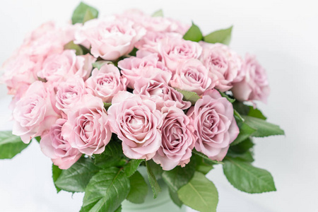 玫瑰丁香和柔和的颜色。金属桶明亮的花束。花店概念