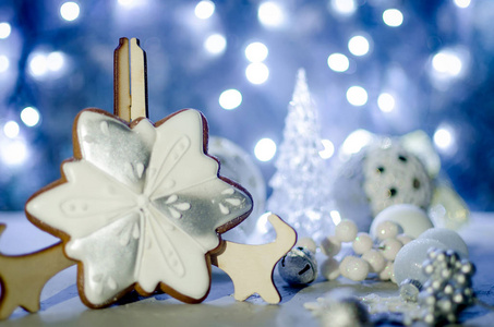 圣诞贺卡与美丽的糖釉圣诞姜饼饼干雪花和白色节日装饰, 球和玩具在黑暗与明亮的散景灯背景, 复制空间