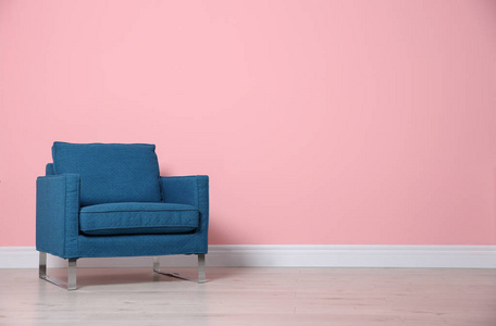 舒适的扶手椅靠近彩色墙壁。现代内部元素