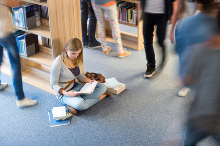 学生坐在地板上图书馆模糊运动图片