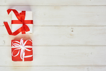 节日背景与白色和红色的礼品盒与缎带在柔和的复古背景。模拟礼品盒和装饰丝带和弓。平躺, 顶部查看照片模拟