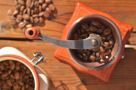 带大咖啡豆的手工咖啡磨床, 有谷物的花瓶, 木板上的咖啡豆