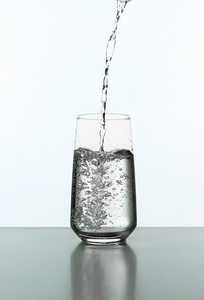 从玻璃上白色孤立的瓶子里倒水