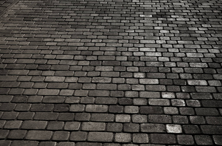 被结合的城市与斑岩立方体。鹅卵石的纹理。一条有石砖的街道的地板。花岗岩鹅卵石铺装路面背景