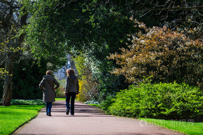 2 女性朋友在一个阳光明媚的春日在公园散步的水平彩色图像