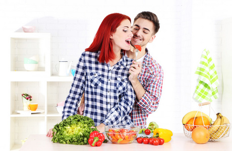 幸福的夫妇准备在厨房里的蔬菜沙拉