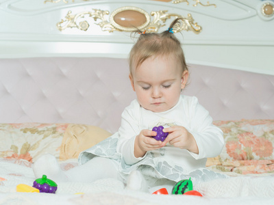 小的白种人孩子女孩玩玩具在家里的床上