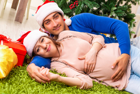 怀孕的妻子 celevrating 圣诞节与丈夫