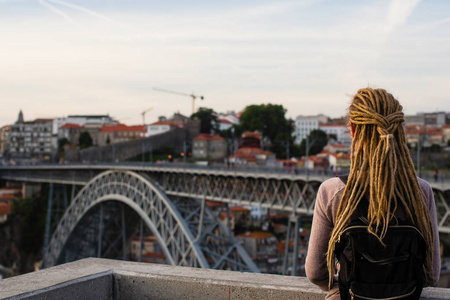 妇女欣赏杜罗河河和 Dom 路易斯 I 大桥在葡萄牙波尔图